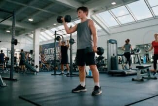 Adolescente en el gimnasio levantando pesas.