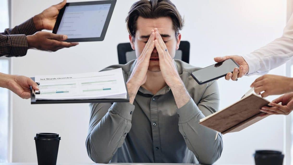 Persona rodeada de pantallas, atrapada por la trampa del multitasking
