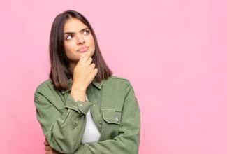 Mujer joven pensativa representando la salud hormonal y la prevención del cáncer.