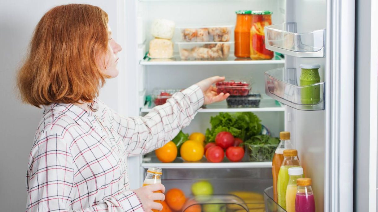 Persona organizando refrigerador para conservar bien los alimentos de forma segura